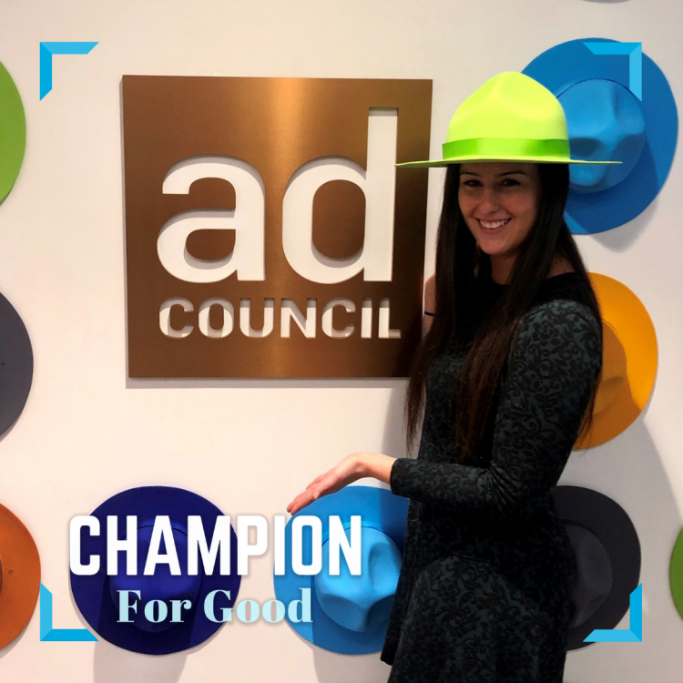 Nikki Silber wears a green Smokey Bear hat in front of a gold Ad Council sign.