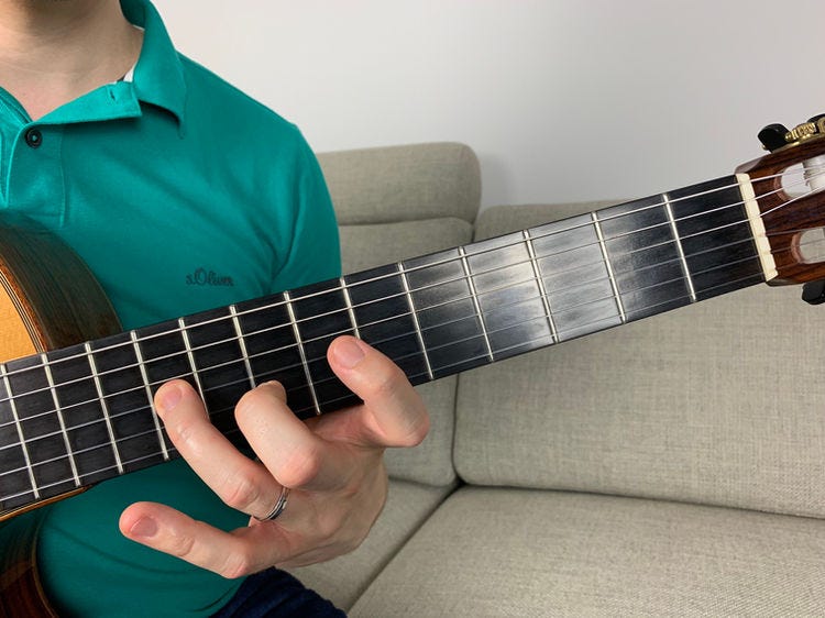 Fingers of the left hand on a guitar’s fingerboard