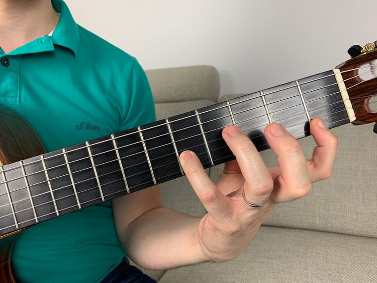 Fingers of the left hand on a guitar’s fingerboard