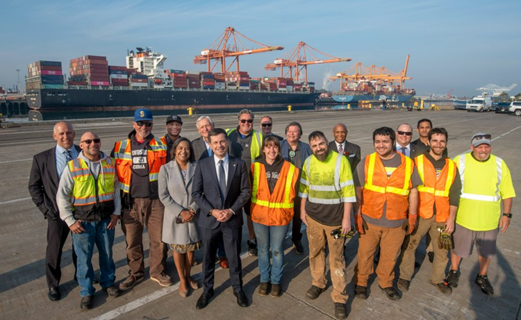 Secretary Buttigieg poses with port workers at the Port of Tacoma.