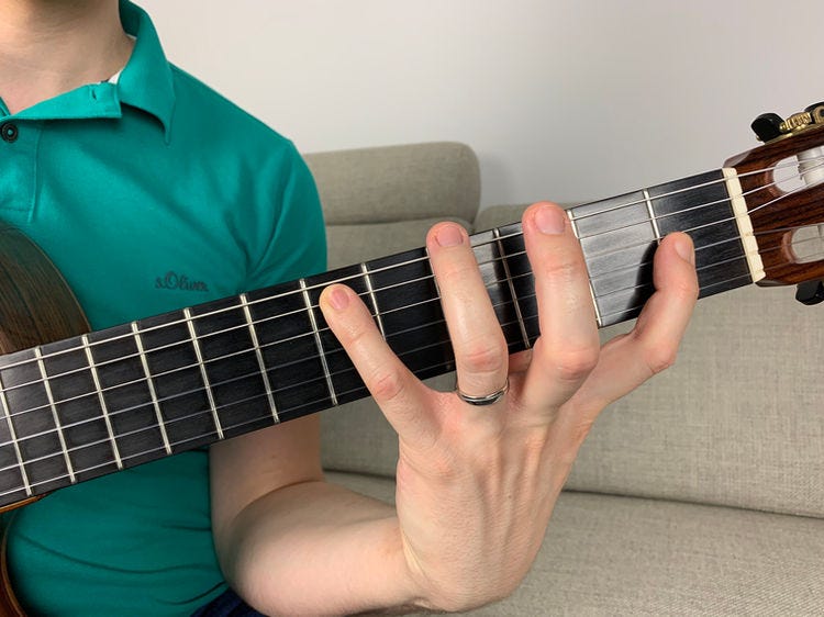 Fingers of the left hand on a guitar’s fingerboard