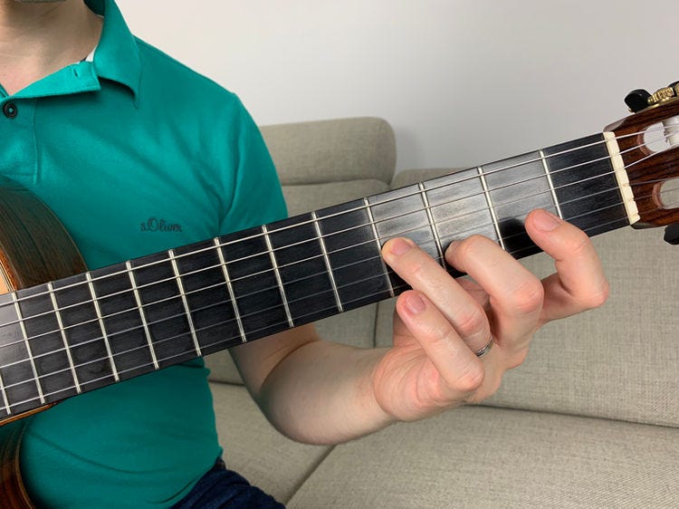 Fingers of the left hand on a guitar’s fingerboard