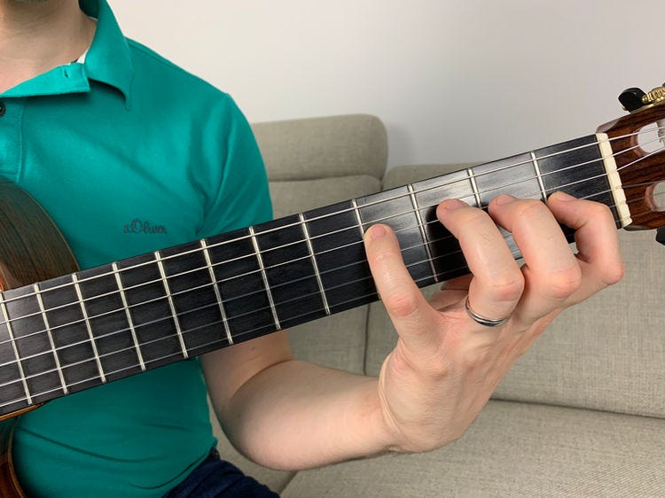 Fingers of the left hand on a guitar’s fingerboard