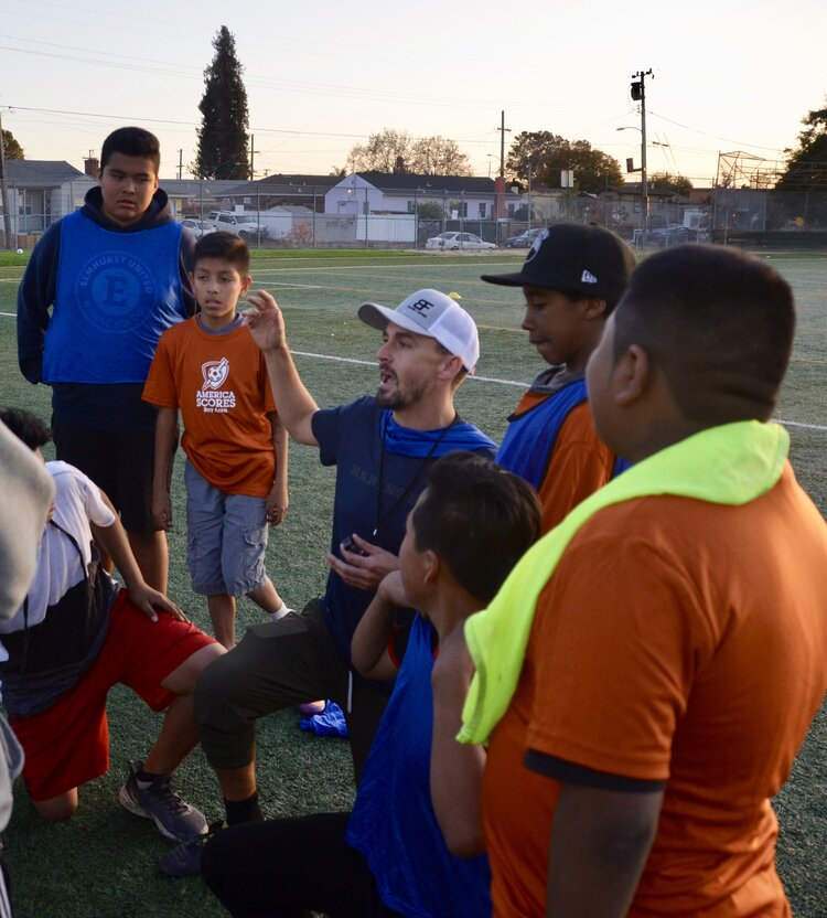 Soccer coach speaking to a group of young soccer players