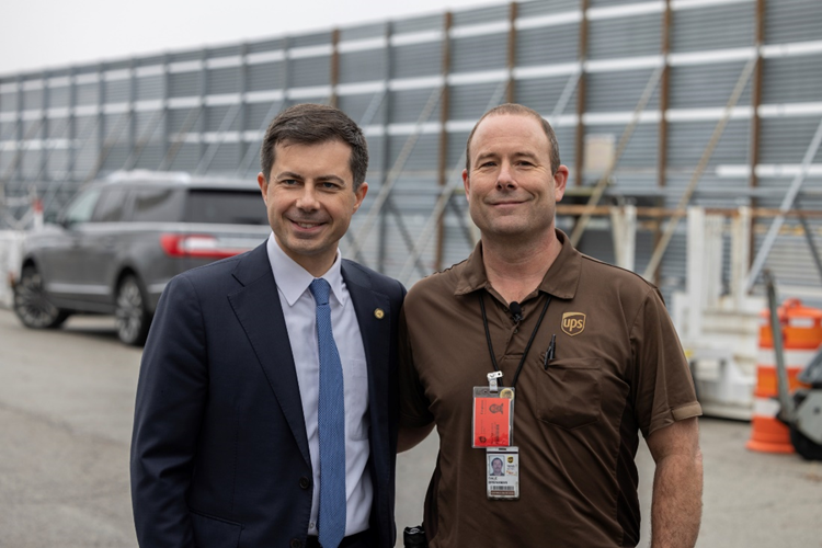 Secretary Buttigieg poses for a photo with a UPS truck driver.