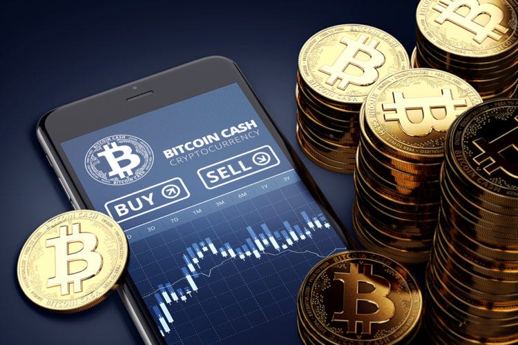 A phone with a stock page for bitcoin open. It is surrounded by piles of coins with a B and two lines like a dollar sign.