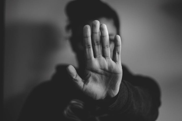 foto em preto e branco de uma mulher com a palma da mão estendida em sinal de pare