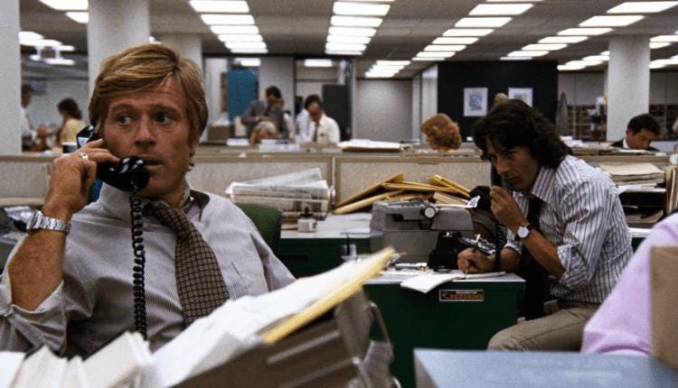 Still from the movie All the President’s Men. Robert Redford and Dustin Hoffman sitting in an office, both on the telephone.