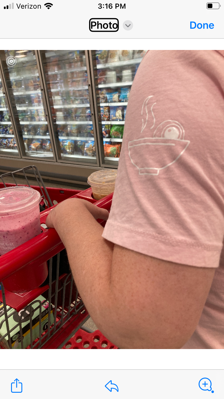 A white outline on a pink shirt sleeve of an eyeball in a steaming bowl of soup.