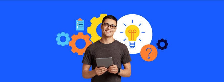 A guy standing in front of a blue screen holding a tab, behind him there are some idea and data sheet design related to tech.