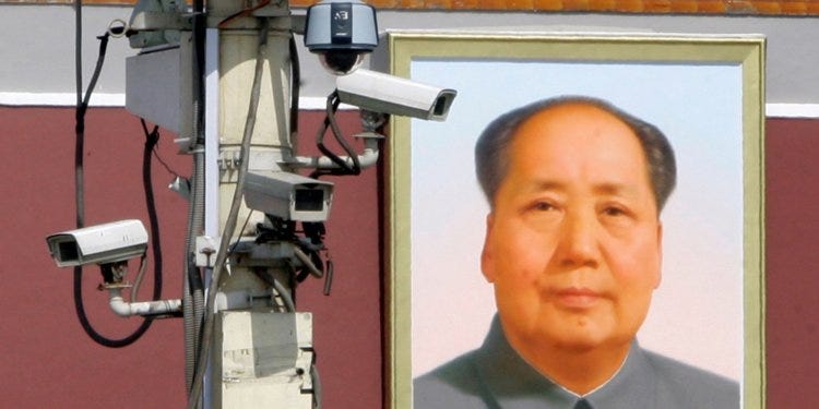 Image of multiple cameras beside portrait of Chinese leader, implying he is watching.