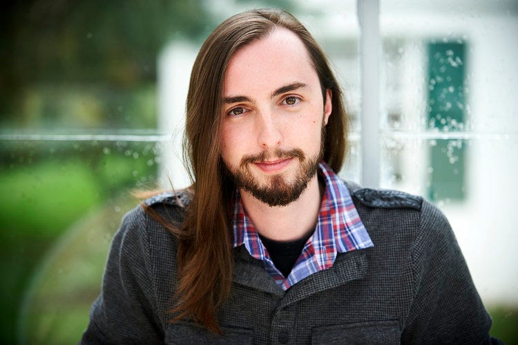 Spencer Creaghan, composer, sitting in front of a window