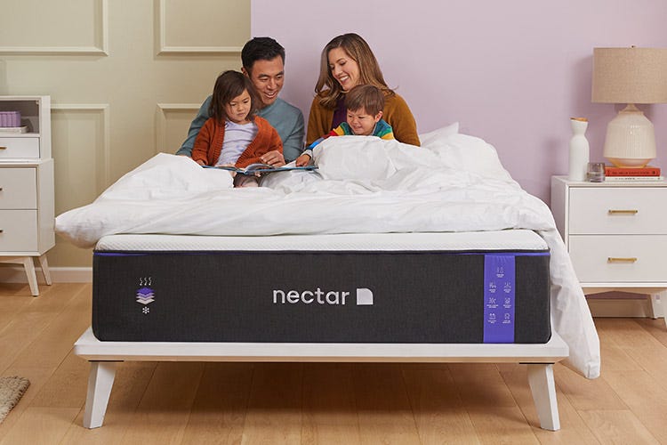 Family lying on Nectar mattress reading