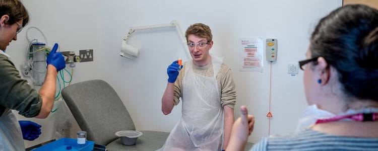 One of the typhoid swallowers gets a thumbs up before downing the vial of live bacteria.