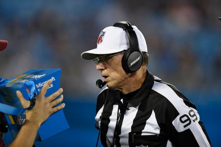 In this Wednesday, Aug. 9, 2017 photo, referee Tony Corrente (99) looks at the instant replay on a Microsoft Surface tablet during the second half of an NFL preseason football game between the Carolina Panthers and the Houston Texans in Charlotte, N.C. (AP Photo/Mike McCarn)