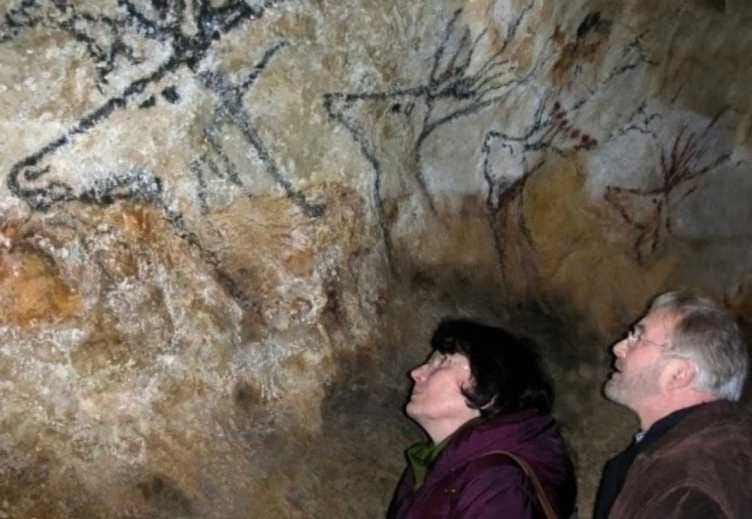 WikiCommons color photo shows B. & G. Delluc in a cave in Lascaux, France, looking up at ancient paintings depicting animals. https://commons.wikimedia.org/wiki/File:B._et_G._Delluc_%C3%A0_Lascaux.jpg