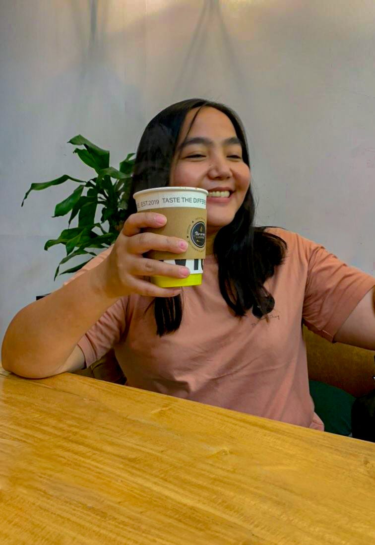 A girl enjoying her cup of good coffee.