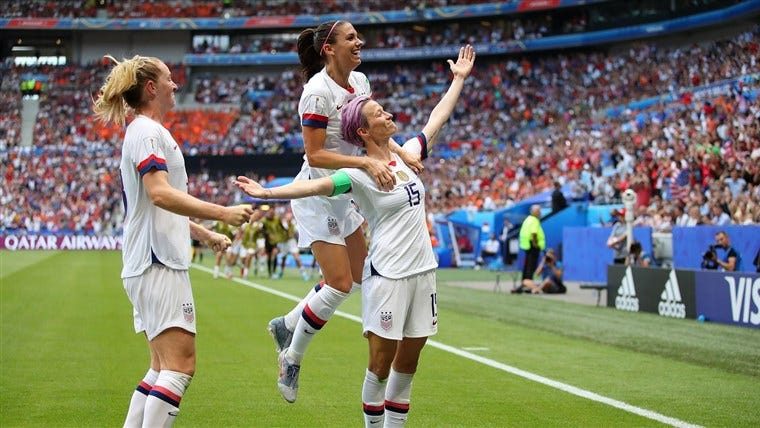 Megan Rapinoe in her iconic arms-out pose and her team celebrating.