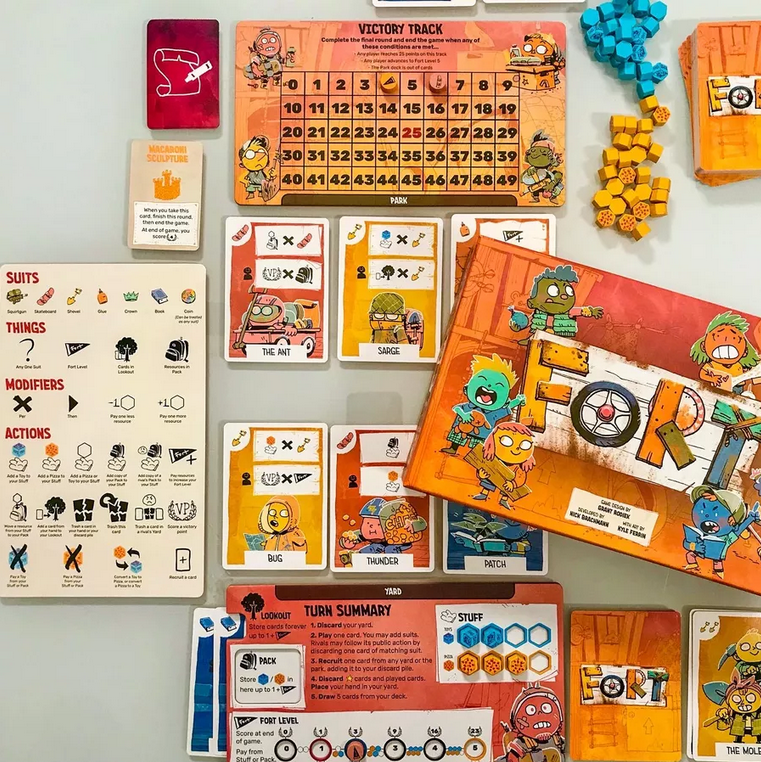 Image showing the components of Fort, including the player aid on the left. The player aid has iconography listed into categories of Suits, Things, Modifiers, and Actions. Actions is the longest section, followed by Suits, and then Things and Modifiers are tied for last place.