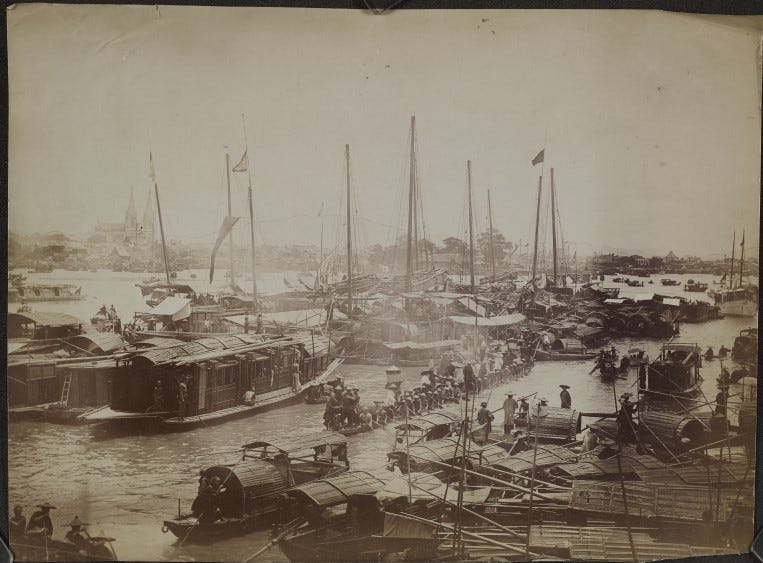 Black and white photograph of a busy harbour with traditional Chinese junk and sampan boats