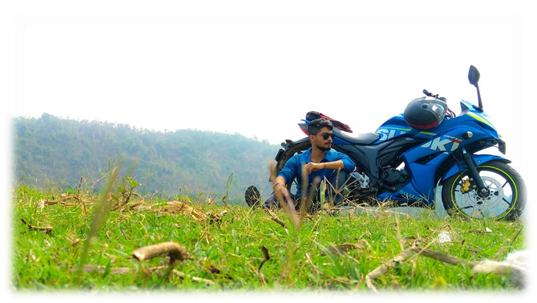 The author sitting on a meadow leaning against his two-wheeler.