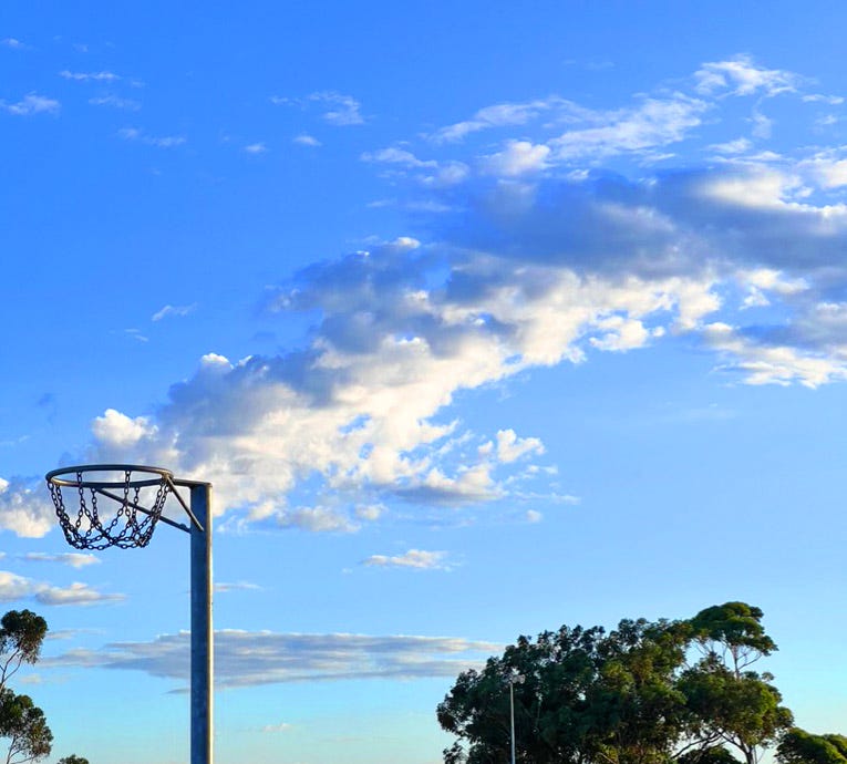 An old netball ring with clouds in the background — it’s like a boiling pot giving off steam.