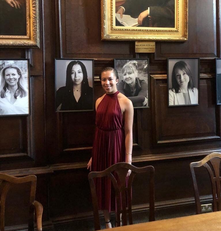 Naomi Kellman stands by her portrait in a dining hall