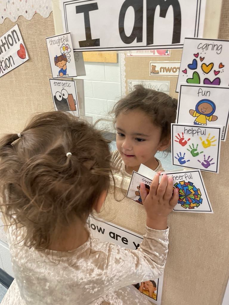 Young child talks to self in mirror