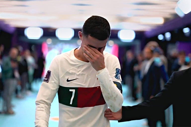Cristiano Ronaldo entrando pelo túnel com a mão esquerda tapando os olhos, chorando pela eliminação de Portugal na Copa do Mundo.