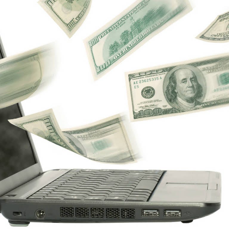 Money flying out of laptop computer showing the money lost from not buying drug rehab marketing