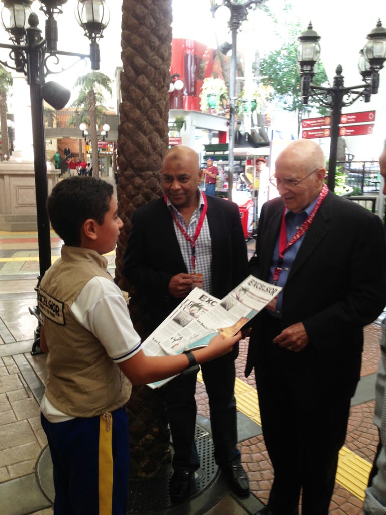 A young reporter gives Prof. Kotler a copy of today's paper.