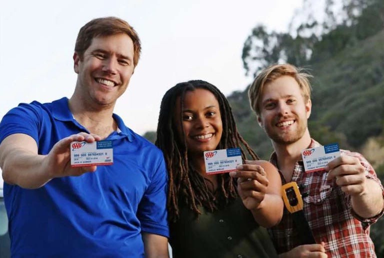 Three adults smiling with their AAA membership cards