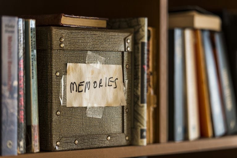 An old box in a bookshelf labeled "memories"