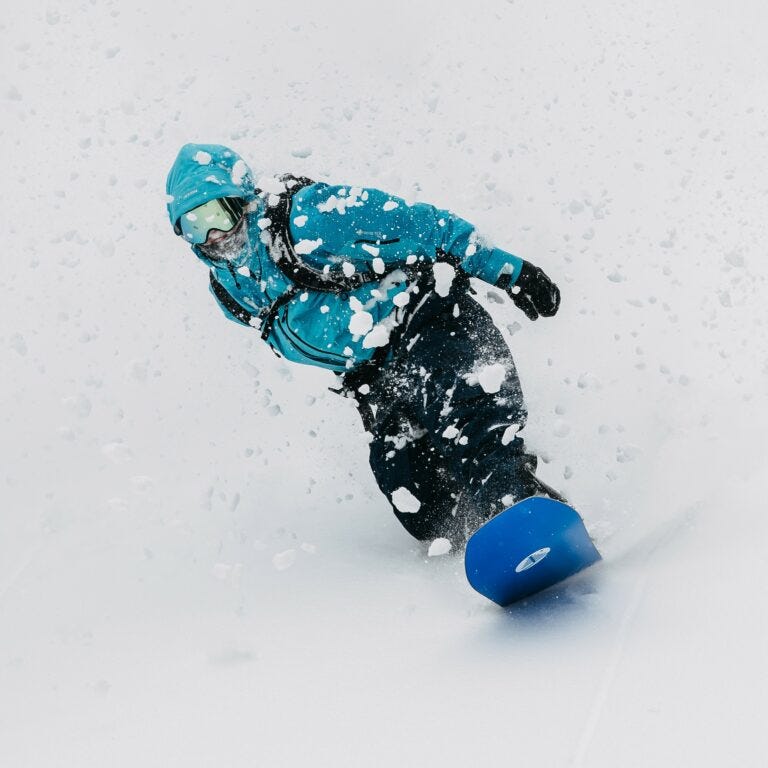 Snowboarder shredding powder down the mountain.