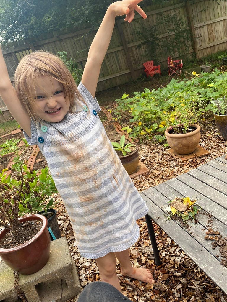 Josie posing with a clay-stained dress in the garden.