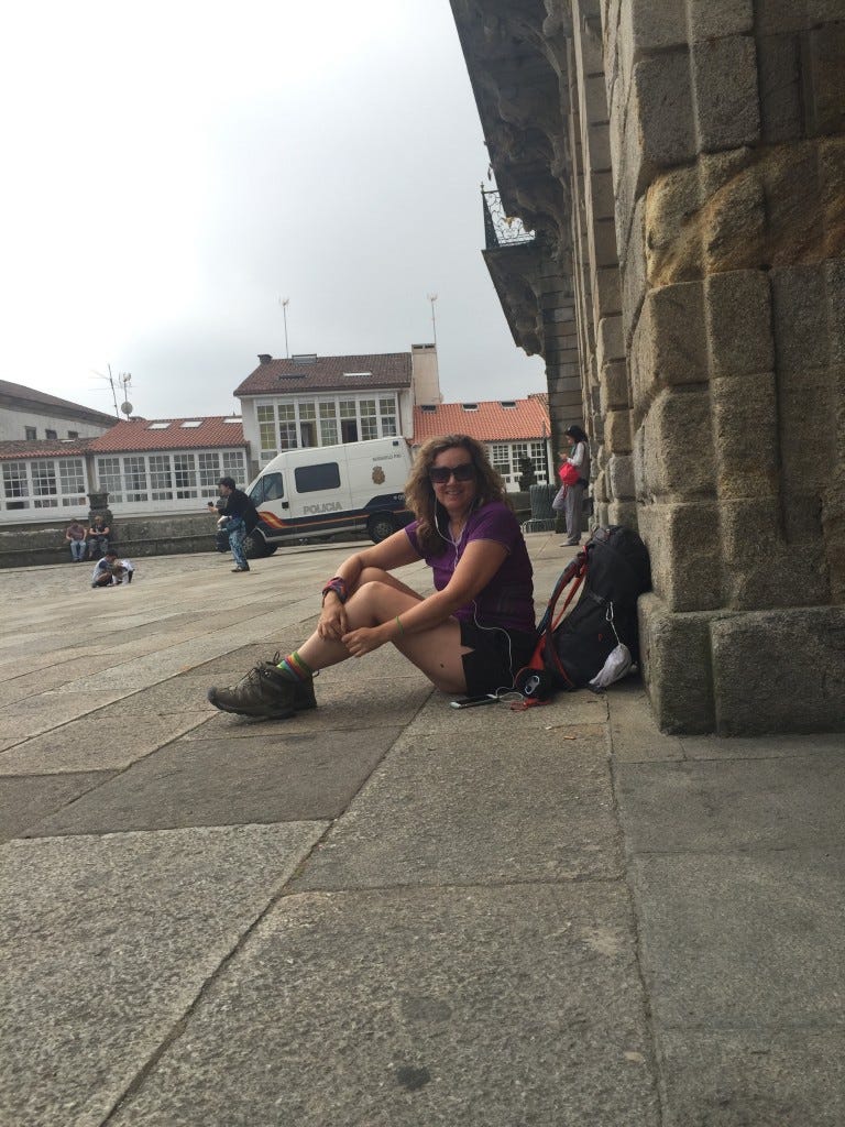 Michelle sitting on the ground after arriving in Santiago de Compostela