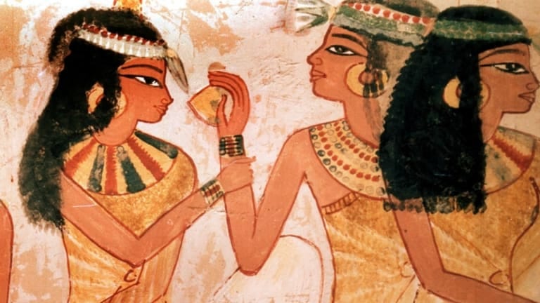 Ancient Egyptian wall-painting of a lady offering another lady a lemon