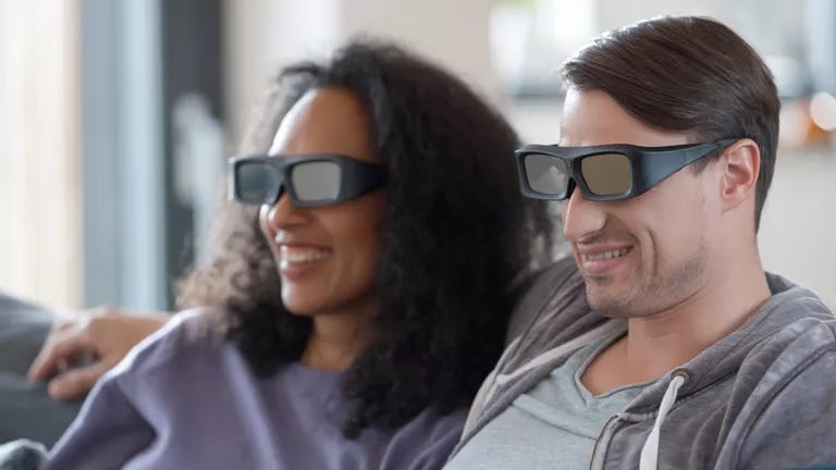 young couple watching 3D tv