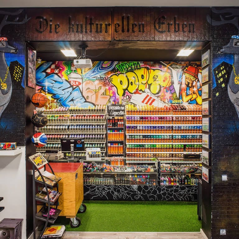 Inside the Legacy shop. A wall covered by colorful spray cans on display.
