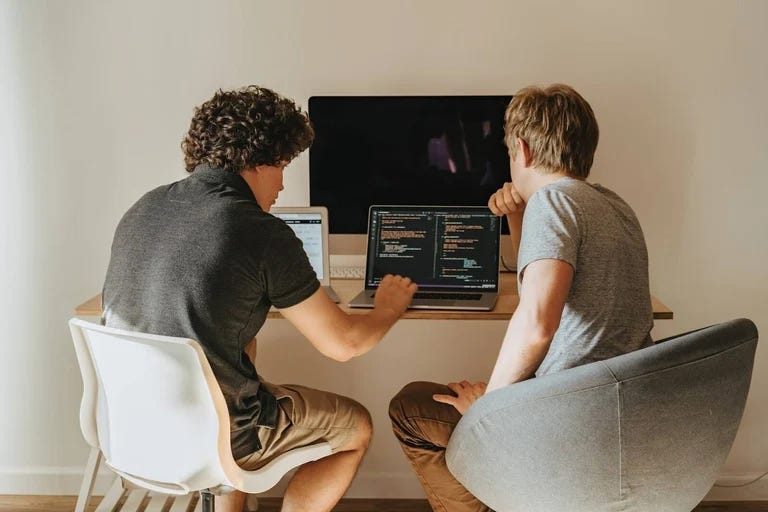two developers writing code together