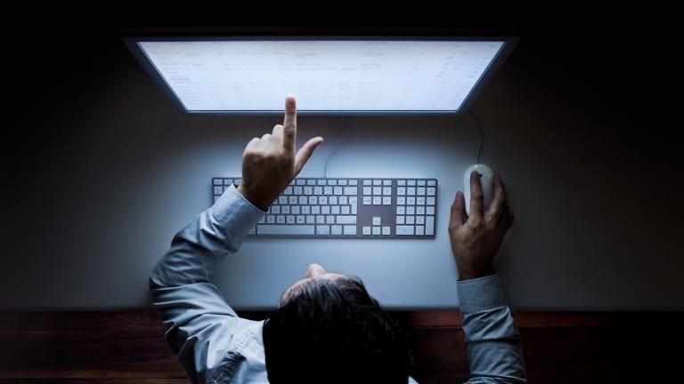 Faceless businessman pointing at computer screen