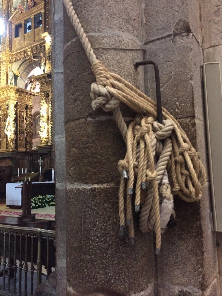 Ropes tied up against a large stone pillar, that are used to pull the Botafumeiro