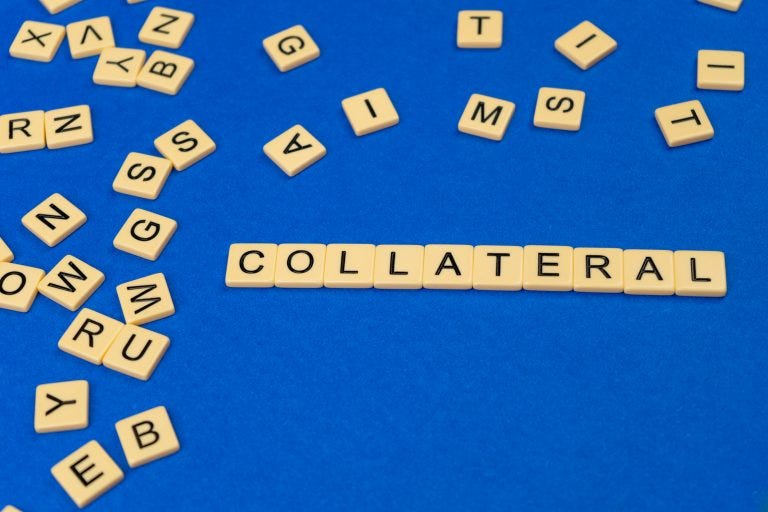 Scrabble words spelling “collateral” on blue cloth background