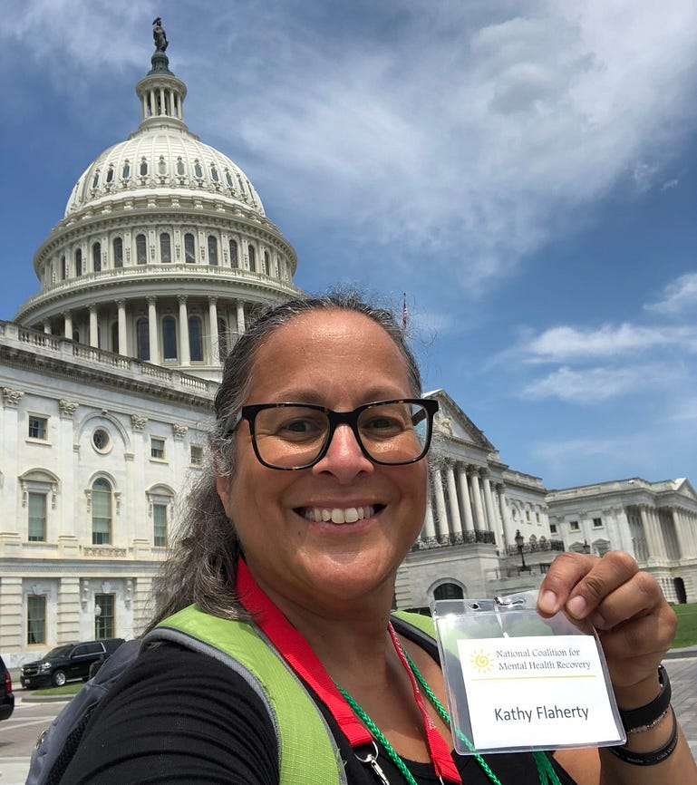 Photo of Kathy Flaherty smiling in front of the United States Capitol building.