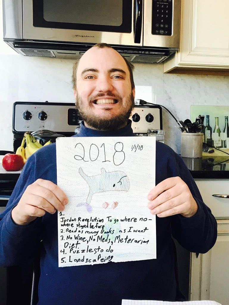 A picture of my son Jordan. He was 34 in this picture. He is sitting with a big smile, holding the picture he drew on New Years Day.