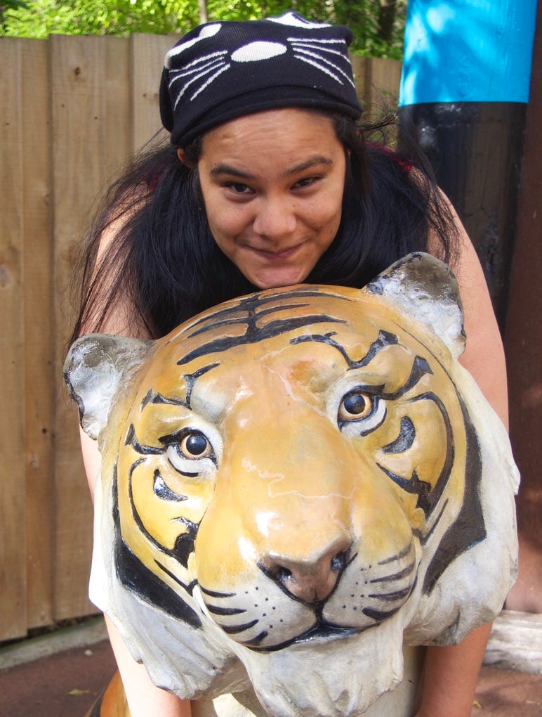 A photo of me from 2014 at Wellington Zoo- I was on top of the lion, and wearing a beanie with a cat face on it