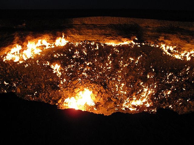 The Darvaza gas crater at night with gas pocket fires glowing inside