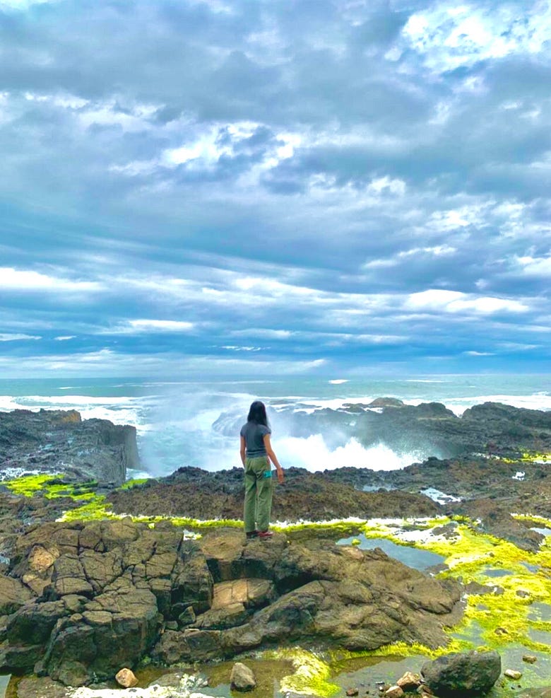 A woman standing in front of Thor’s Well