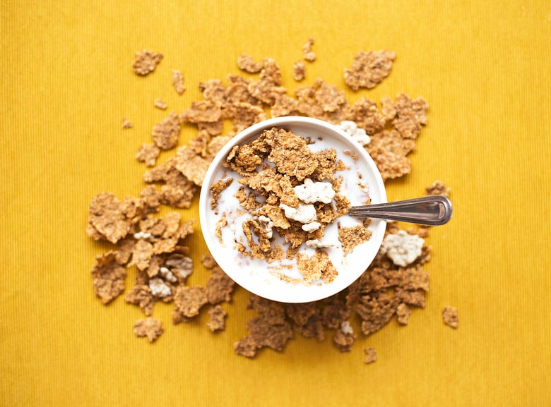 A bowl of cereal on a yellow table.