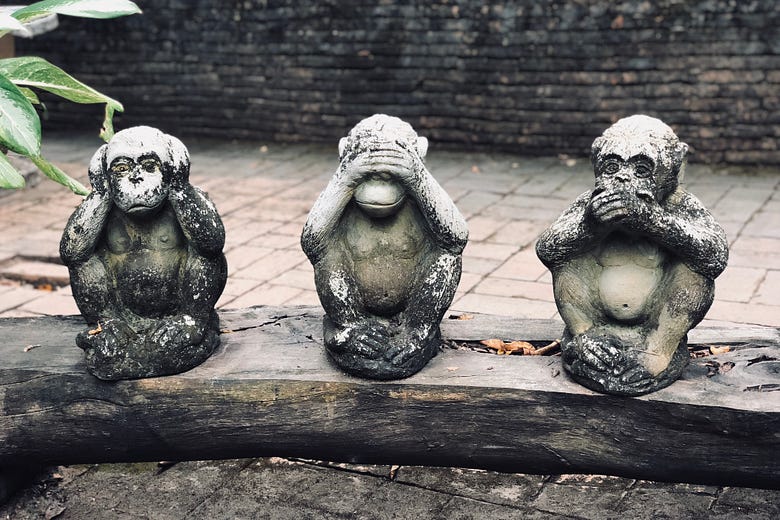 3 statues of monkeys with one holding its ears, one holding its eyes, and one holding its mouth